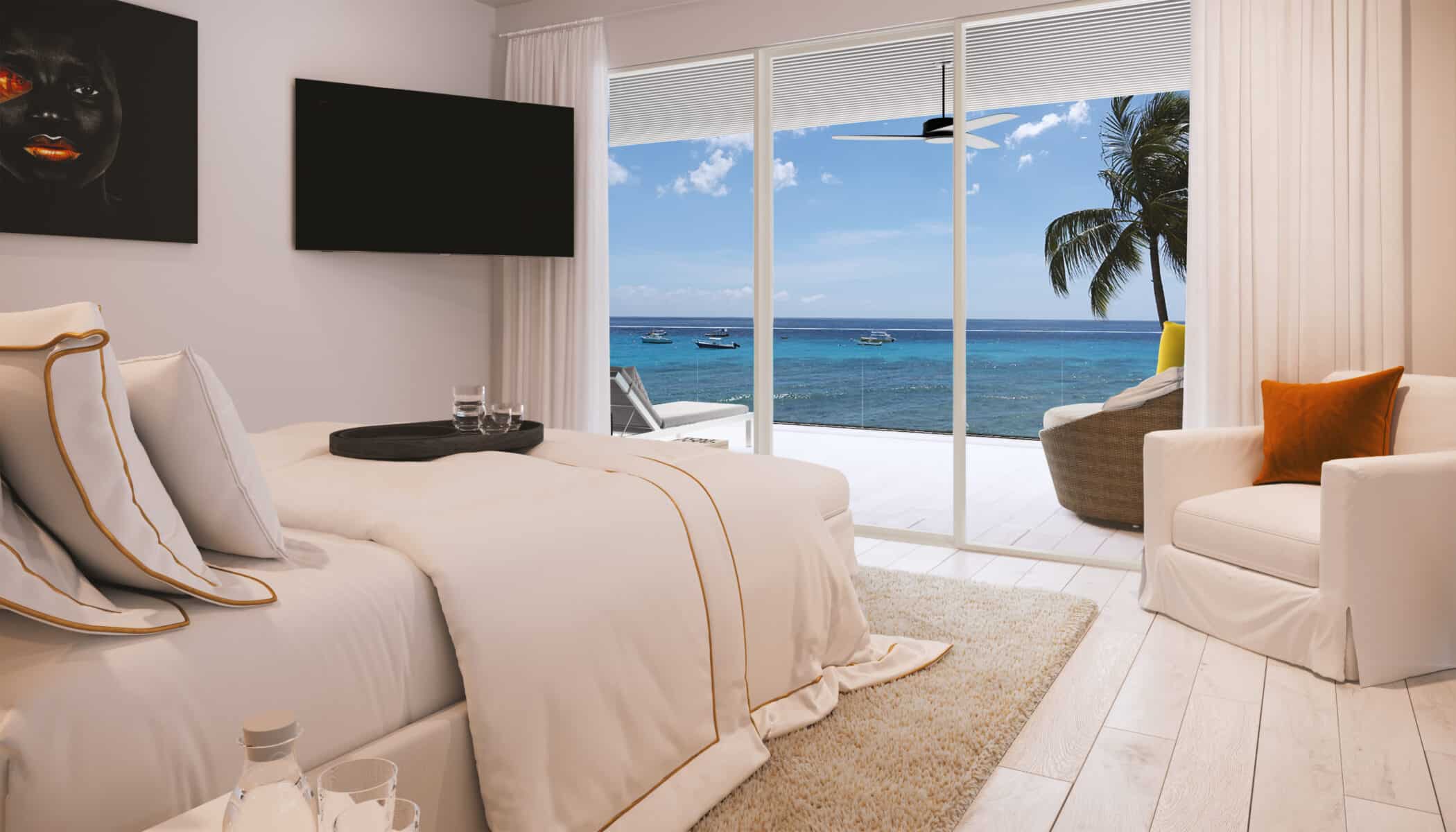 A modern Solaris Beach House hotel room with a large bed, white and beige decor, a TV, and sliding glass doors opening to a balcony overlooking the ocean with boats and palm trees.